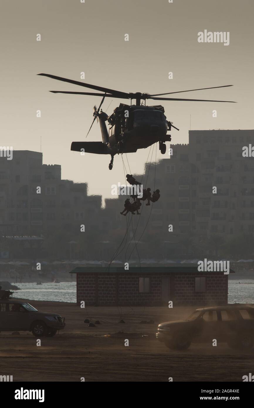 Militärischen Kampf und Krieg mit dem Hubschrauber in das Chaos und Zerstörung zu fliegen. Soldaten aus Seil auf den Boden von Chopper aussetzen. Militärisches Konzept Stockfoto