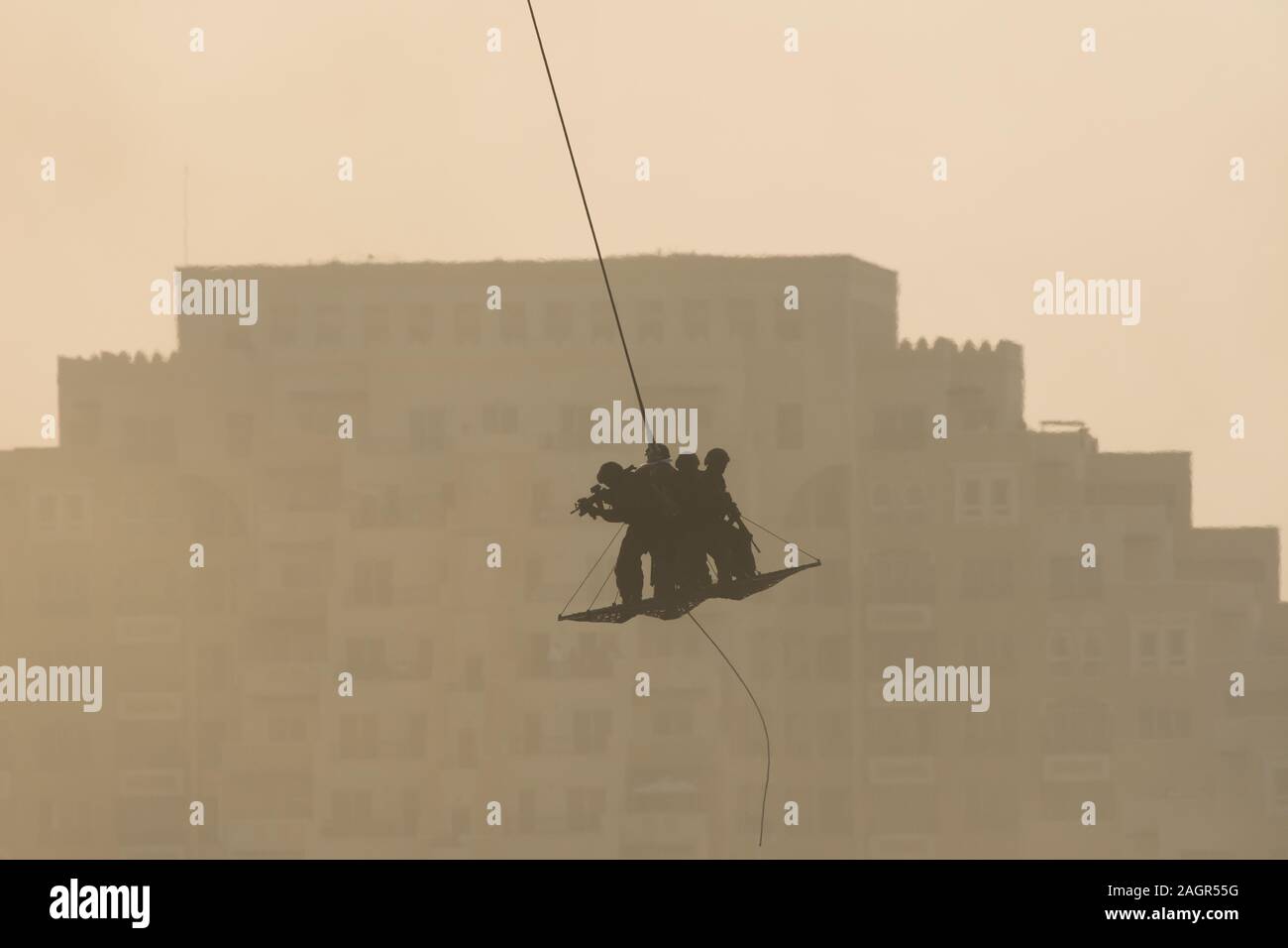 Militärische Team in Konflikt Rettung durch Helikopter. durch die Luft fliegen auf einem Seil befestigt im Rauch und Dunst in den Nahen Osten zu Häcksler Stockfoto