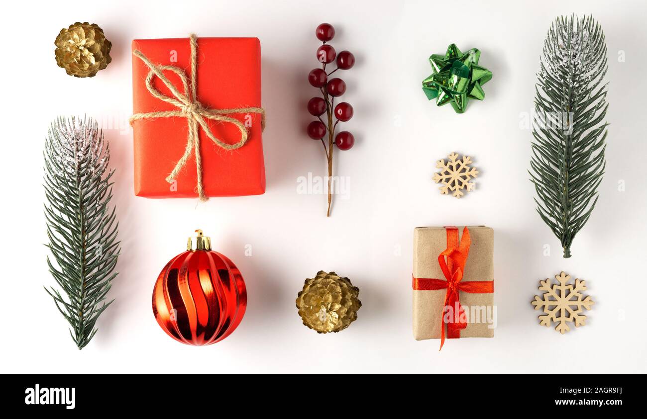 Kreatives Konzept noch Life Urlaub Foto von Pine Tree Branches Beeren mit Weihnachten Spielzeug Dekorationen und Gegenwart Geschenkboxen auf weißem Hintergrund. Stockfoto