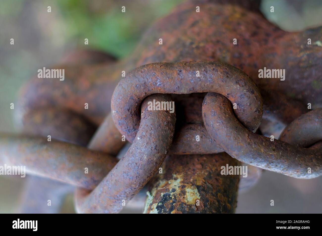 Der Rest der rostige Kette, ein Link eines rostigen Kette auf einem rostigen Stange. Reste von Farbe werden sichtbar und die Kette ist aus nächster Nähe fotografiert. Stockfoto