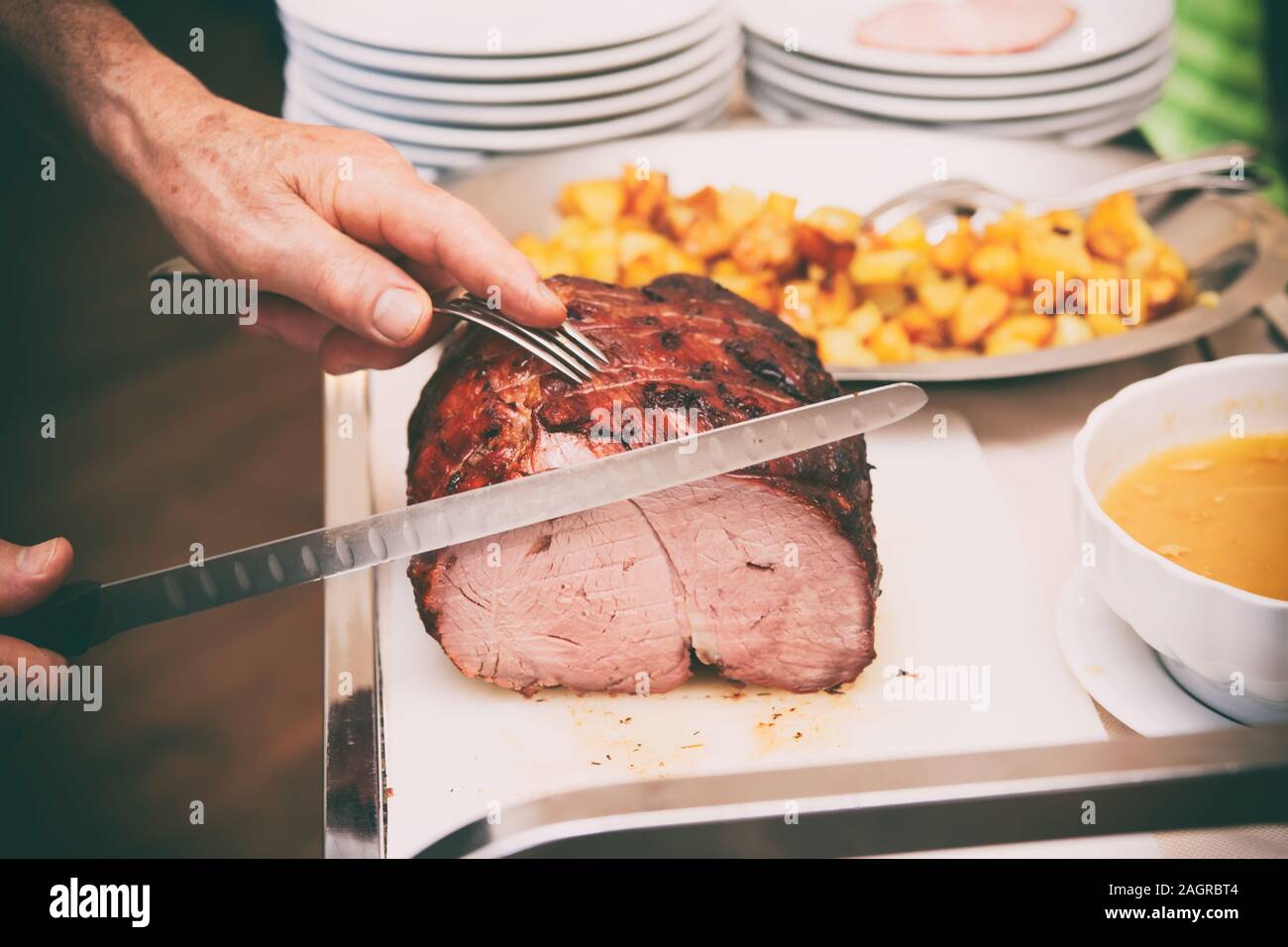 Koch ist Schneiden Beefsteak mit Schinkenmesser, getönten Bild Stockfoto