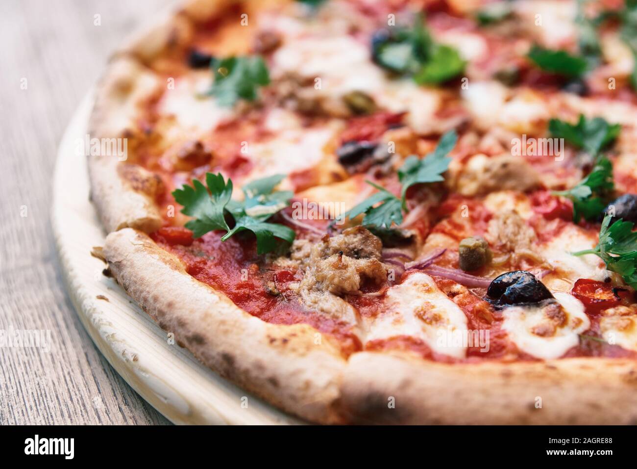Pizza mit Fleisch und Soße puttanesca, Nahaufnahme, getönten Bild Stockfoto