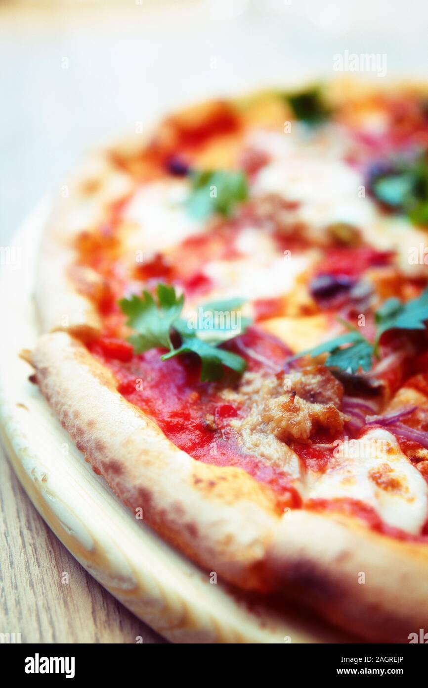 Pizza mit Fleisch und Soße puttanesca close-up, getönten Bild Stockfoto