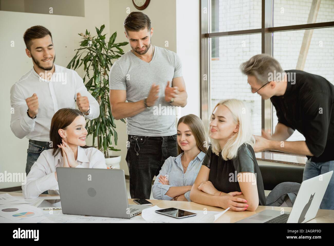 Mitarbeiter applaudieren, einem von ihnen ein junge Frau Anerkennung und Respekt erreicht hat. Stockfoto