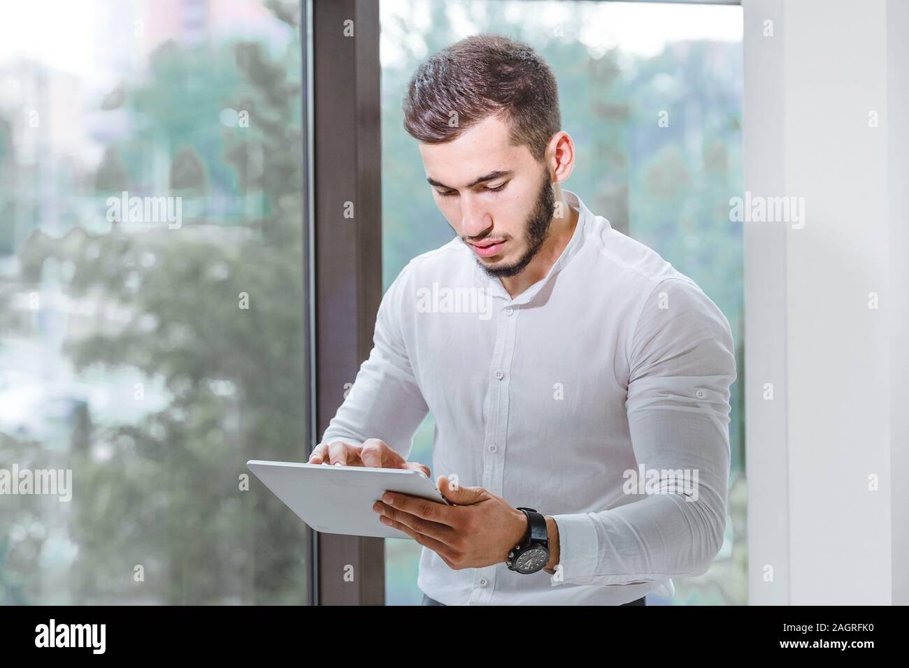 Nahaufnahme des jungen arabischen ethnency mit Tablet PC-Mann indoor Stockfoto