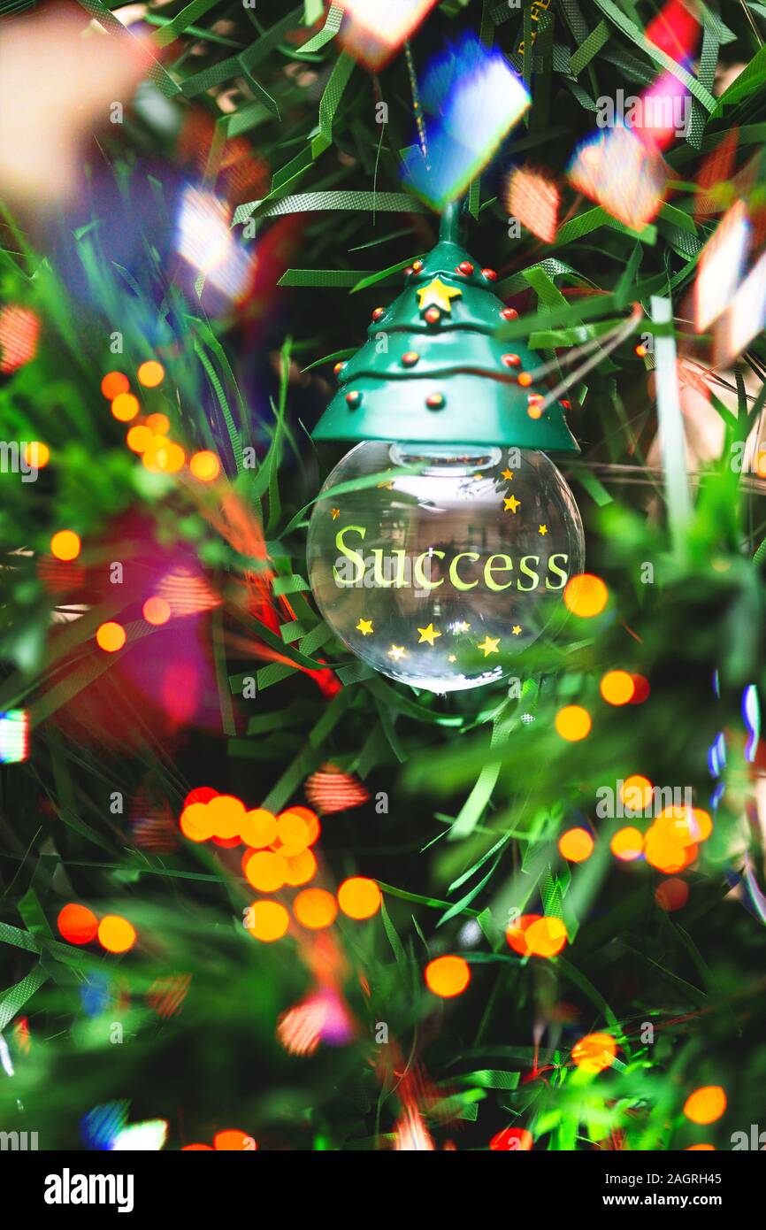 Glas Kugel mit dem Wort hängen in der Weihnachtsbaum ERFOLG. Konzept des Jahres erfolgreich Grußkarte Stockfoto