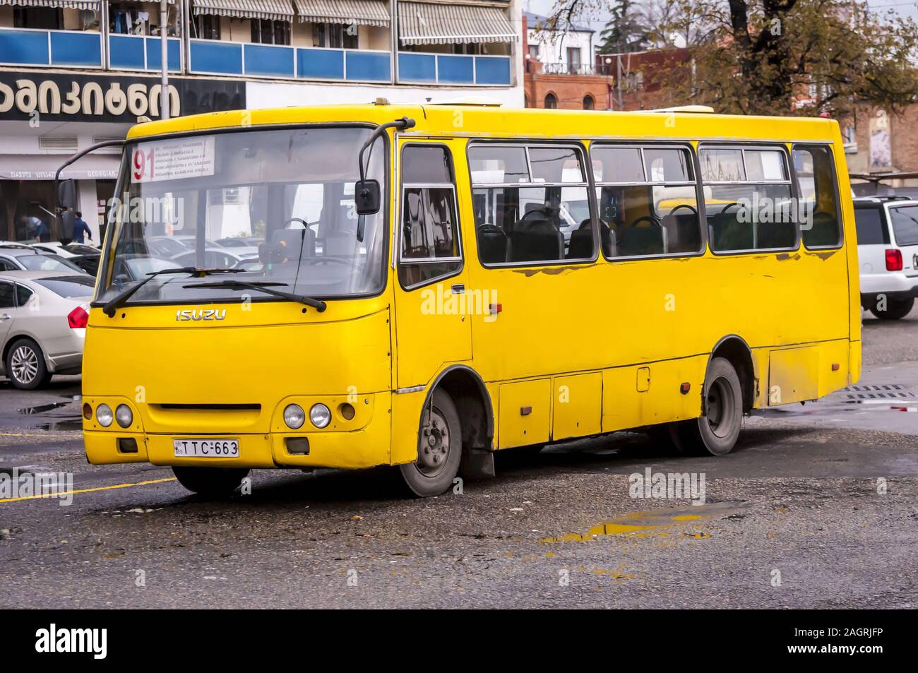 TIFLIS, GEORGIEN. November 2019. Gelber Isuzu Route Pendlerbus, der von der U-Bahn-Station Avlabari in der Innenstadt von Tiflis geparkt wird. Stockfoto