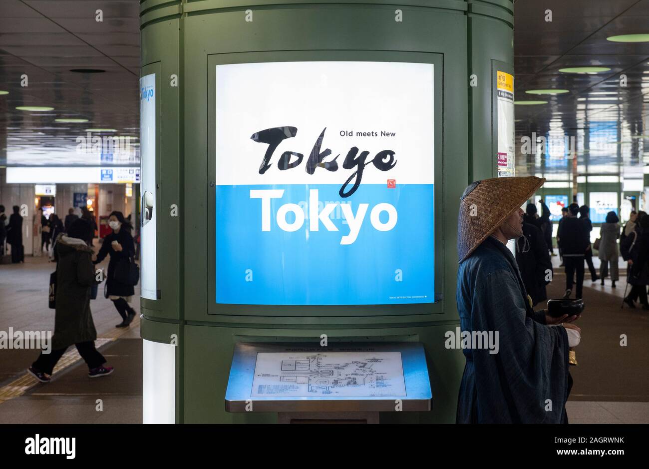 Ein Mann mit traditionellen Japanischen Tüchern gekleidet bitten Sie um Geld in Tokio Bahnhof. Stockfoto