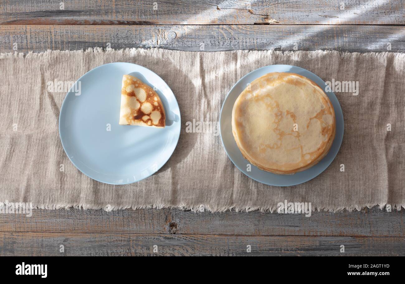 Kochen Pfannkuchen. Fastnacht Maslenitsa () - blini Stapel auf einem blauen Schild an einem hölzernen Tisch. Selektive konzentrieren. Stockfoto