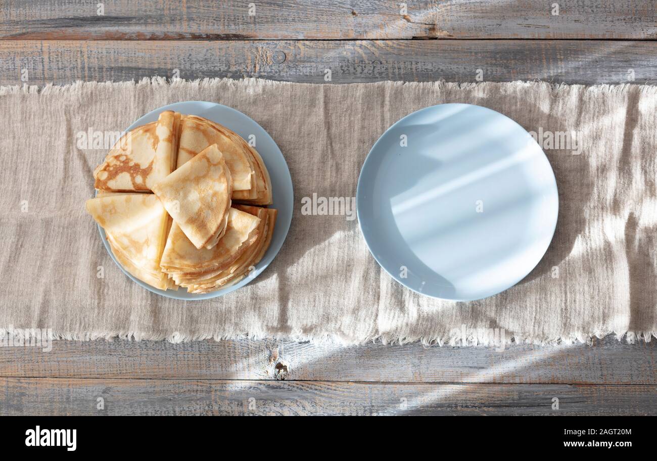 Kochen Pfannkuchen. Fastnacht Maslenitsa () - blini Stapel auf einem blauen Schild an einem hölzernen Tisch. Selektive konzentrieren. Stockfoto