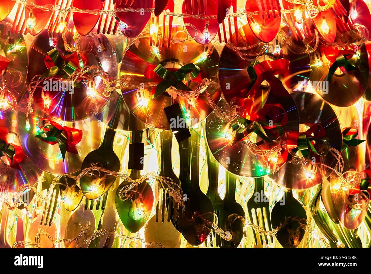 Nahaufnahme einer Weihnachtsdekoration von recyceltem Utensilien und Compact Discs mit warmen Weihnachtsbeleuchtung, auf den Philippinen gesehen kombiniert Stockfoto