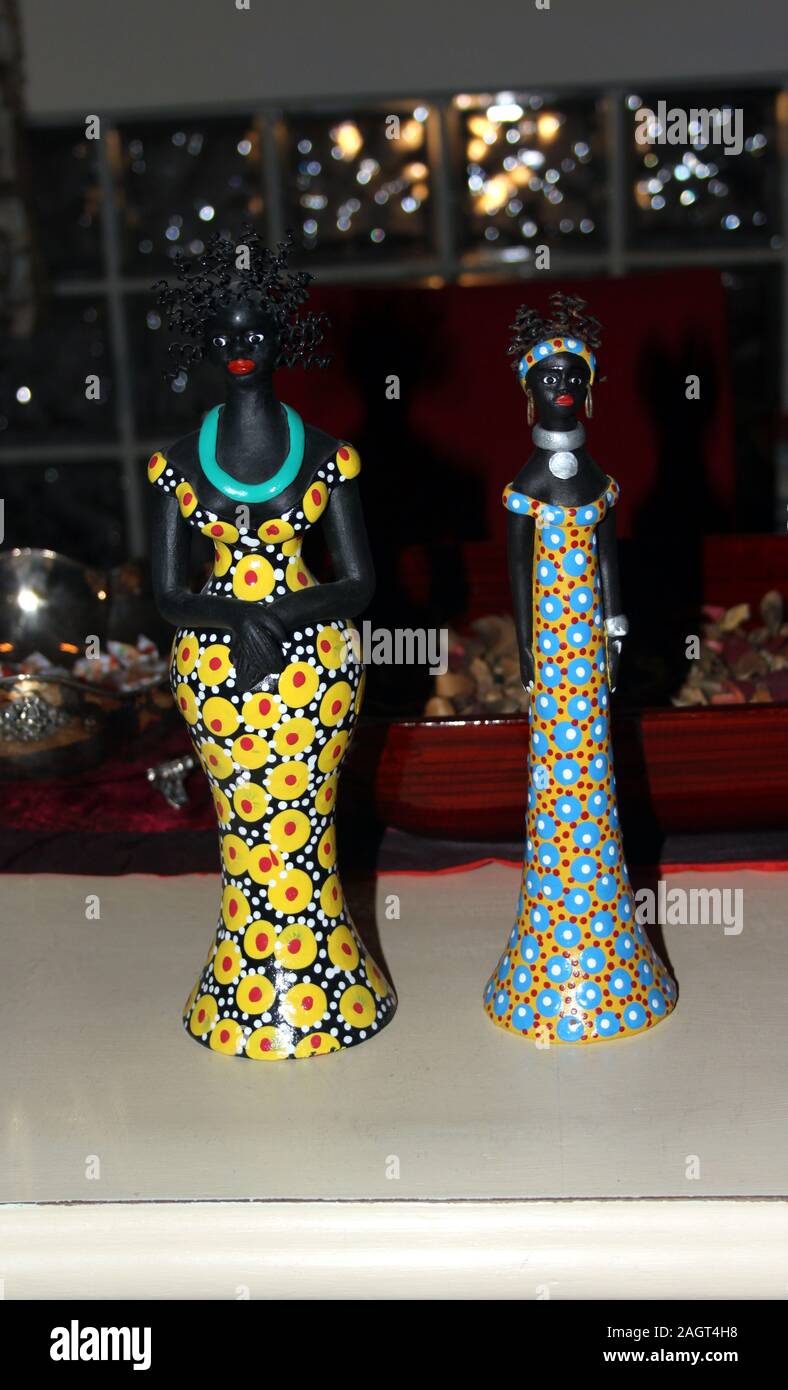 Zwei kleine Statuen von afrikanischen Frauen mit bunten Kleidung Stockfoto