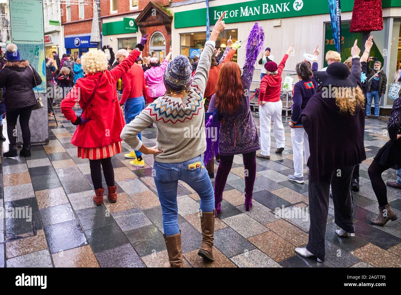 Mitglieder der Isle of man Extinction Rebellion Group tanzen in der Strand Street zum Überleben während der Weihnachtseinkäufe im Dezember 2019 Stockfoto