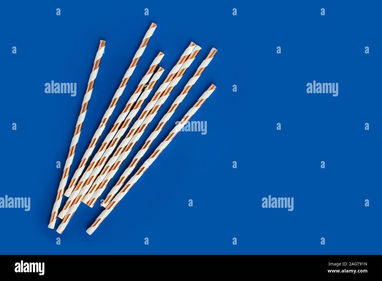 Hintergrund aus Cocktail Strohhalme mit goldenen Streifen auf der blauen Farbe. Stockfoto
