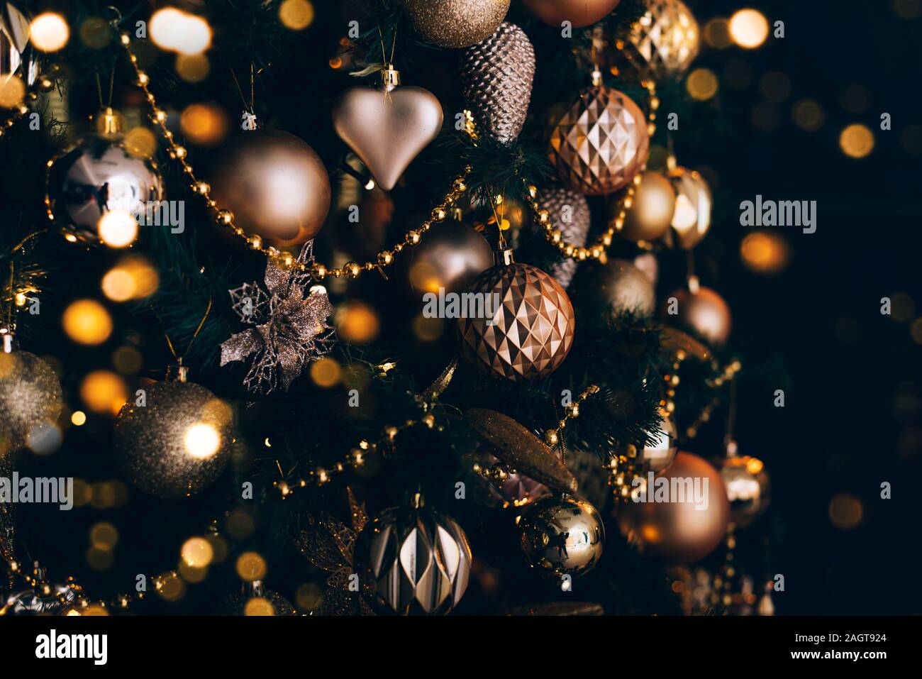 Geschmückten Weihnachtsbaum mit goldenen Spielzeug auf dunklem Hintergrund. Weihnachten Konzept, 2020. Stockfoto