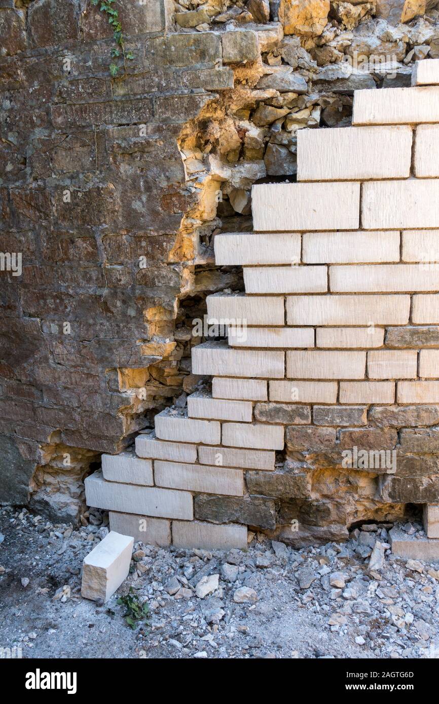 Instandsetzung einer alten gewölbten Stein Garten Wand durch Austausch von alten verfallenen Steine mit Neuen Stockfoto