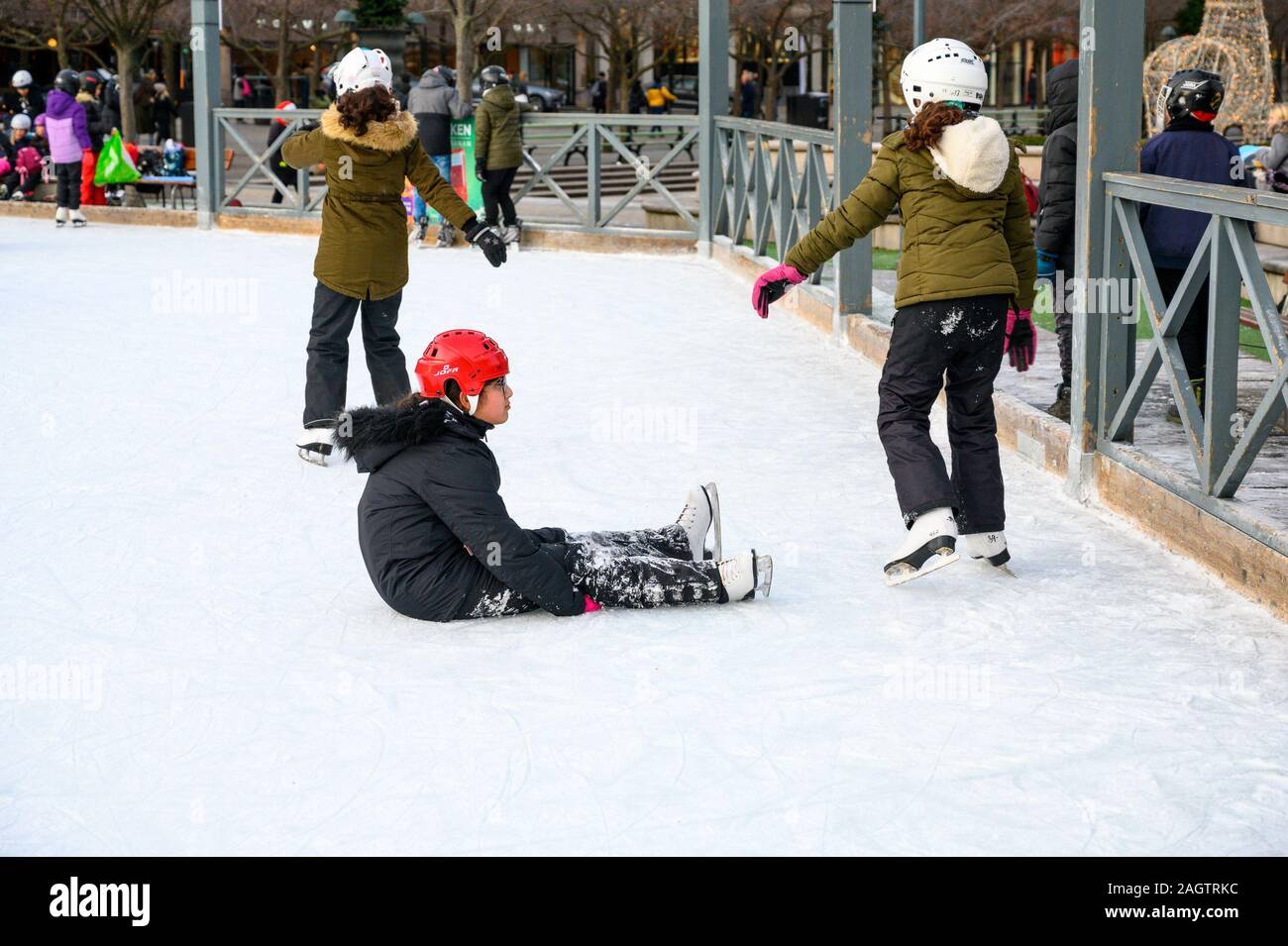 Schweden, Stockholm, 18. Dezember 2019: winterliche Atmosphäre der Stadt. Schule Kinder im Eisstadion in der Stadt. Traditionelle Eislaufbahn im Park Kun Stockfoto