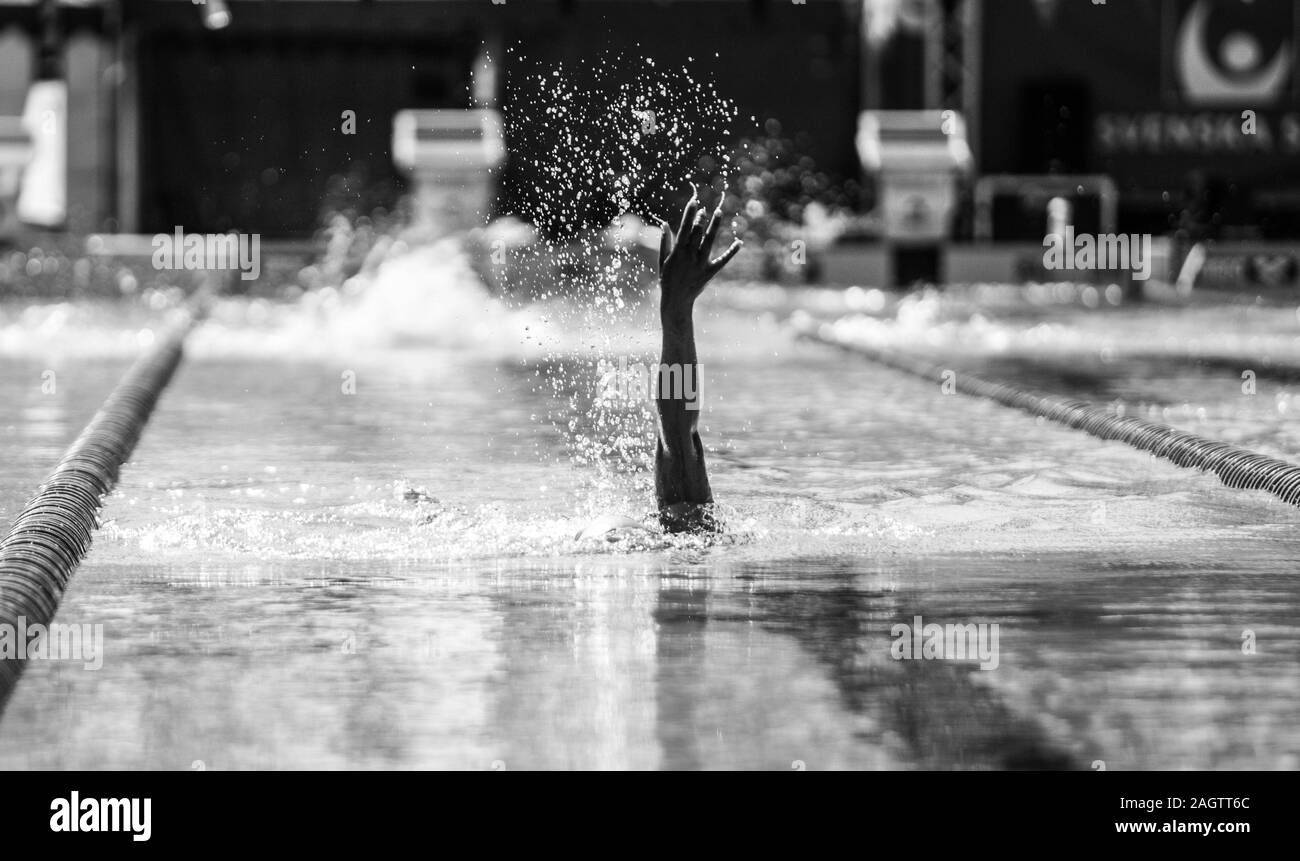 Graustufenaufnahme einer Hand eines Schwimmers während einer Schwimmwettbewerb Stockfoto