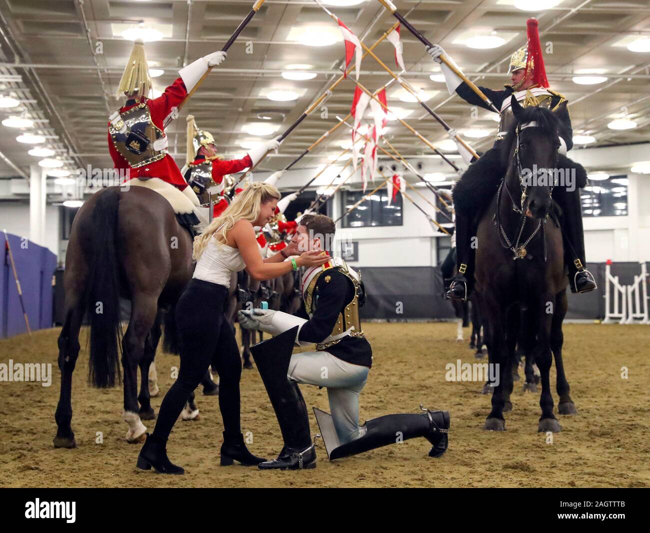 Household Cavalry Trooper Jonathan Adams schlägt seine Freundin Megan Baldry bei Tag sechs der London International Horse Show in London Olympia. Stockfoto