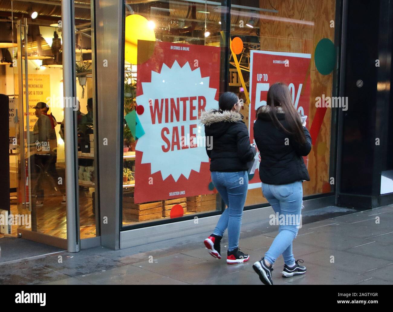 Käufer vorbei an einem anderen Store mit Verkauf Zeichen, wie viele Geschäfte in London Premier Einkaufsviertel Oxford Street und haben bereits schwere Diskontierung und Verkäufe, die in der Regel nicht bis Weihnachten beginnen gestartet. Stockfoto