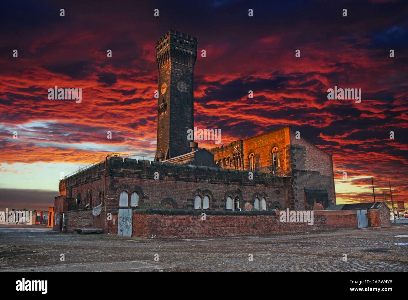 März 27, 2010 - Birkenhead Dock, Liverpool, England, Vereinigtes Königreich. Ein alter Turm sitzt verfallene, gegenüber einem Mittelwert roten und schwarzen Himmel. Die Uhr re Stockfoto