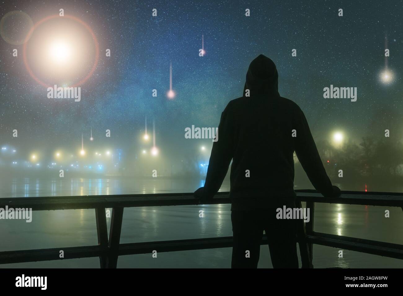 Eine vermummte Gestalt gegen Alien, UFO silhouetted, Raumschiff leuchtet neben einem Fluss. Auf einer geheimnisvollen Nebel, Winter, Nacht, mit einem Universum von Sternen. 21.12.2006 Stockfoto