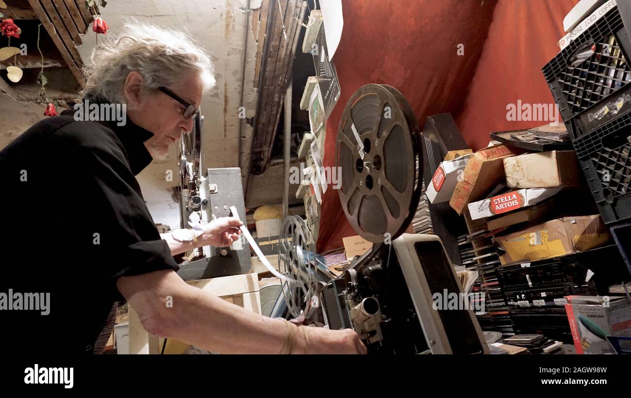 Experimentelle Filmemacher Craig Baldwin Einfädeln eines 16-mm-Film Projektor in seinem Keller Filmarchiv und Studio. Baldwin ist der Kurator der anderen Kino. Stockfoto