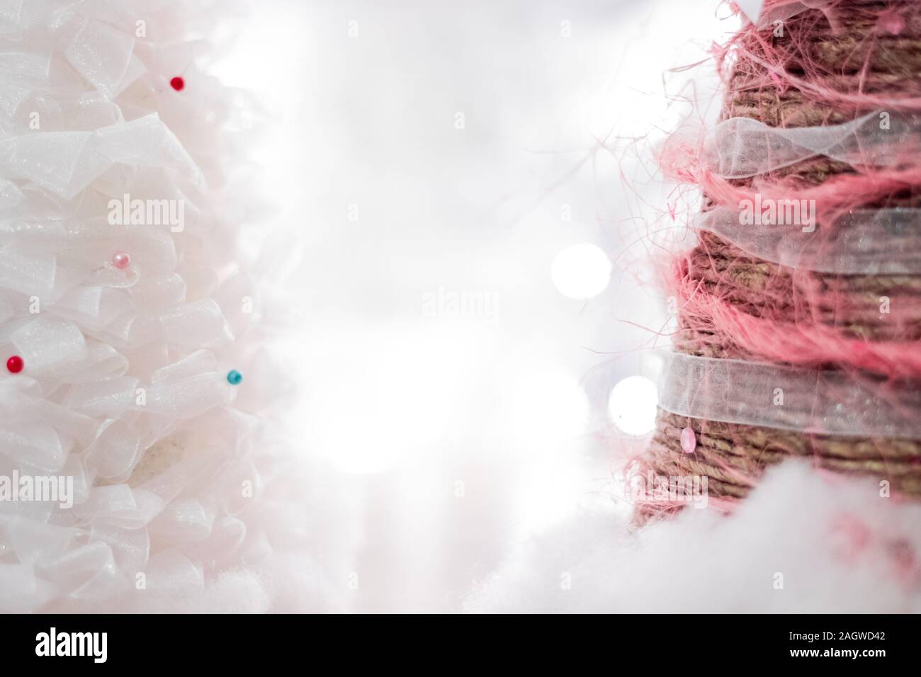 Soft Focus helle Weihnachten Hintergrund mit kopieren. Kleine niedliche handgefertigte dekorative xmas Bäume aus weißer Spitze, Garn und auf weiße Lichter bokeh def Stockfoto
