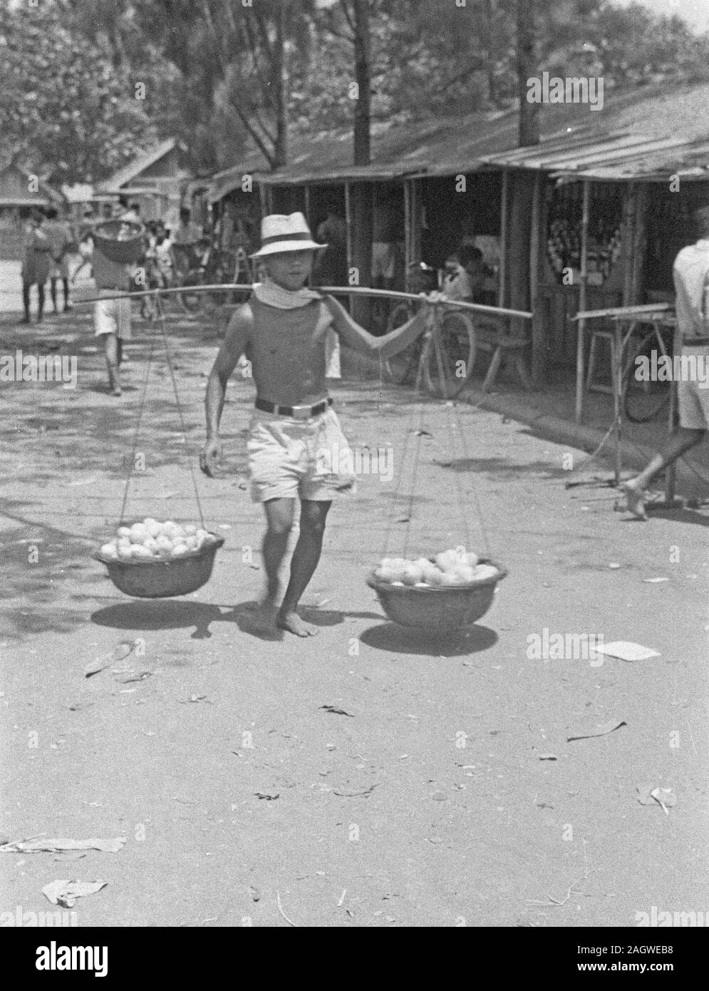 1947 - Obst Verkäufer mit Körben auf der Gabel in Indonesien, Niederländisch Ostindien Stockfoto