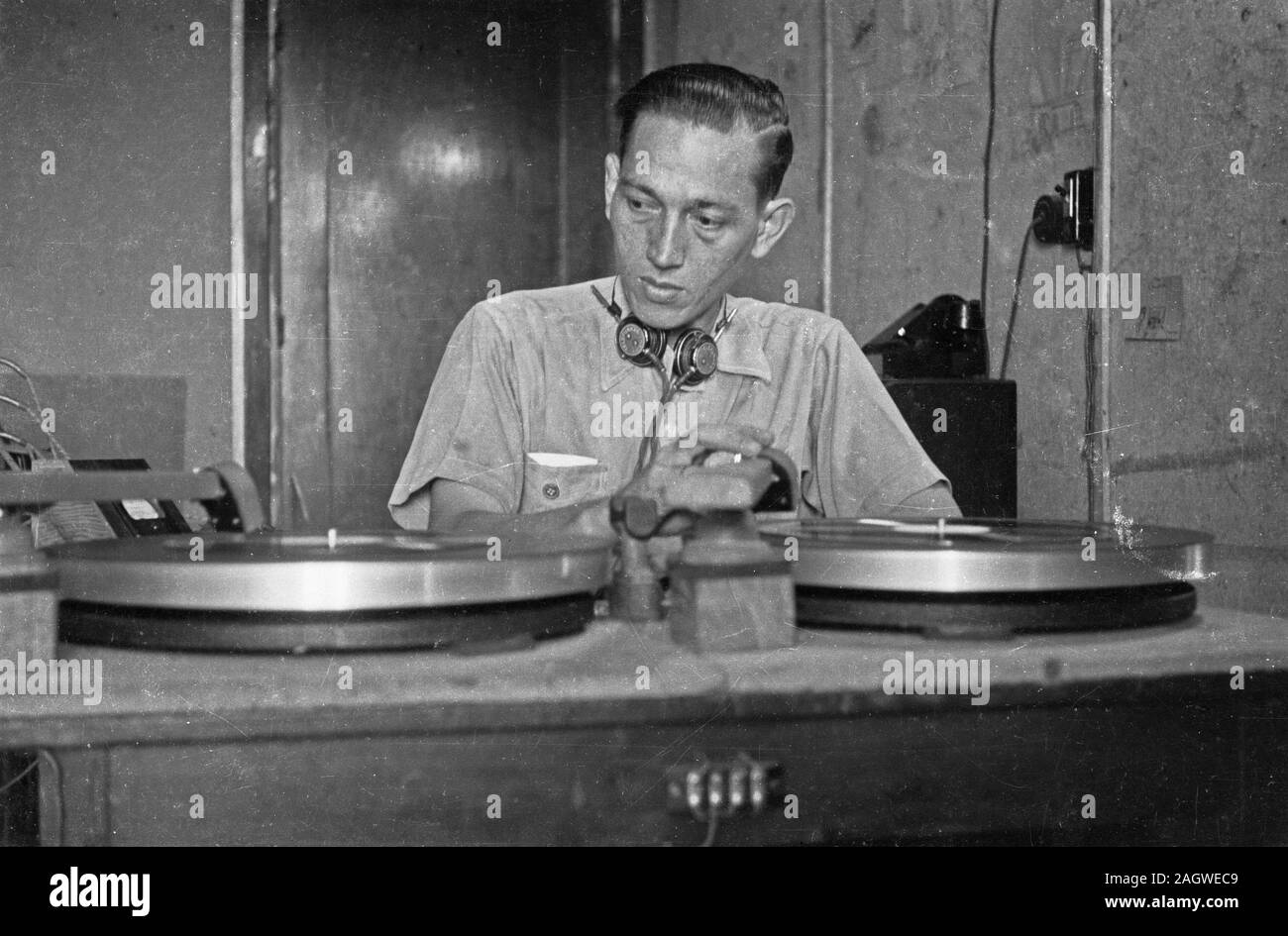 1947 - Schallplatten sind auf Plattenspieler. Dahinter ein Techniker - Indonesien, Niederländisch Ostindien Stockfoto