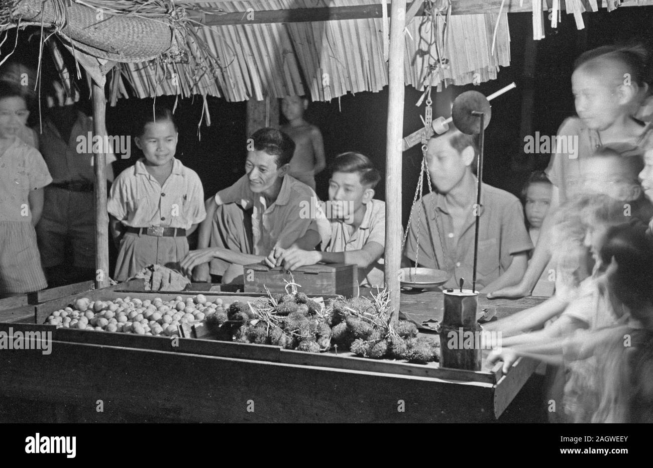 Mann Verkauf von Obst in einem in Banka, Indonesien, Niederländisch Ostindien stall Ca. 1947 Stockfoto