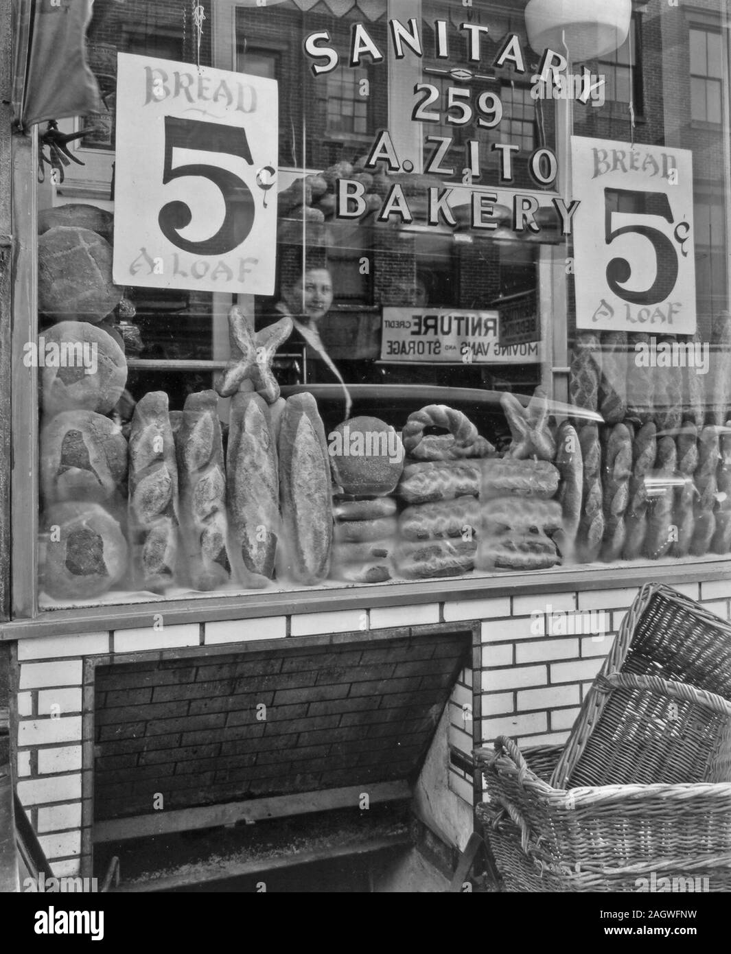 Suchen im Fenster der A. Zito Sanitär Bäckerei, mit Mann und Frau innen heraus suchen, Anzeichen für 5 Cent Brote, Reflexionen der Straße im Fenster. Stockfoto