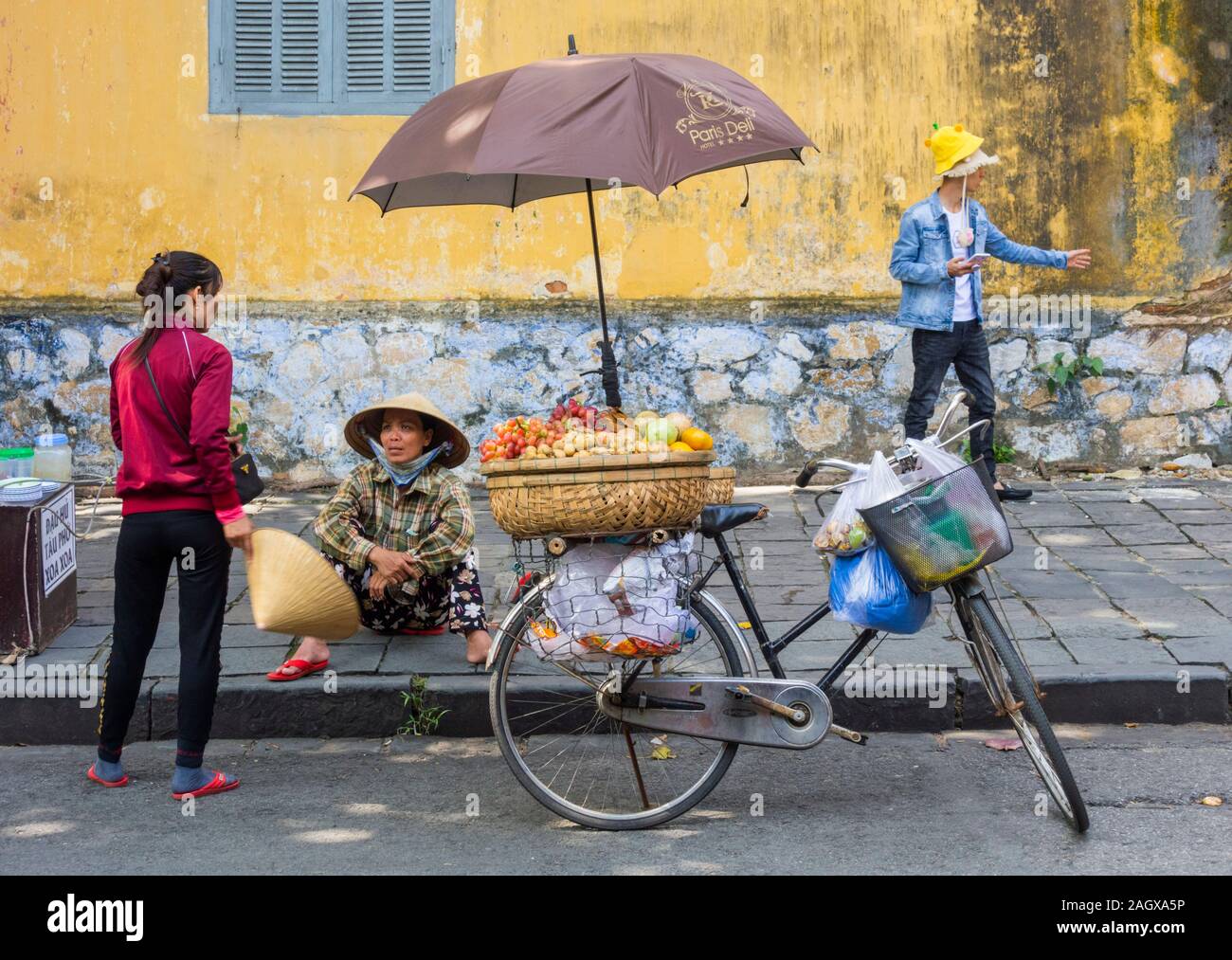 Vietnamesische Straßenhändler sitzt auf Pflaster eine Pause, Hoi An Stockfoto
