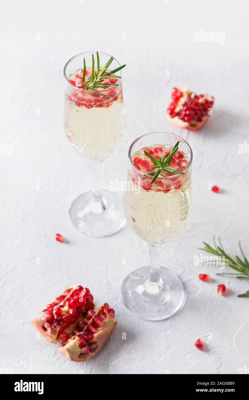 Zwei Glas Granatapfel Weihnachten Cocktail mit Rosmarin Zweig, Sekt, club Soda auf weißer Tisch. Xmas trinken. Close Up. Stockfoto