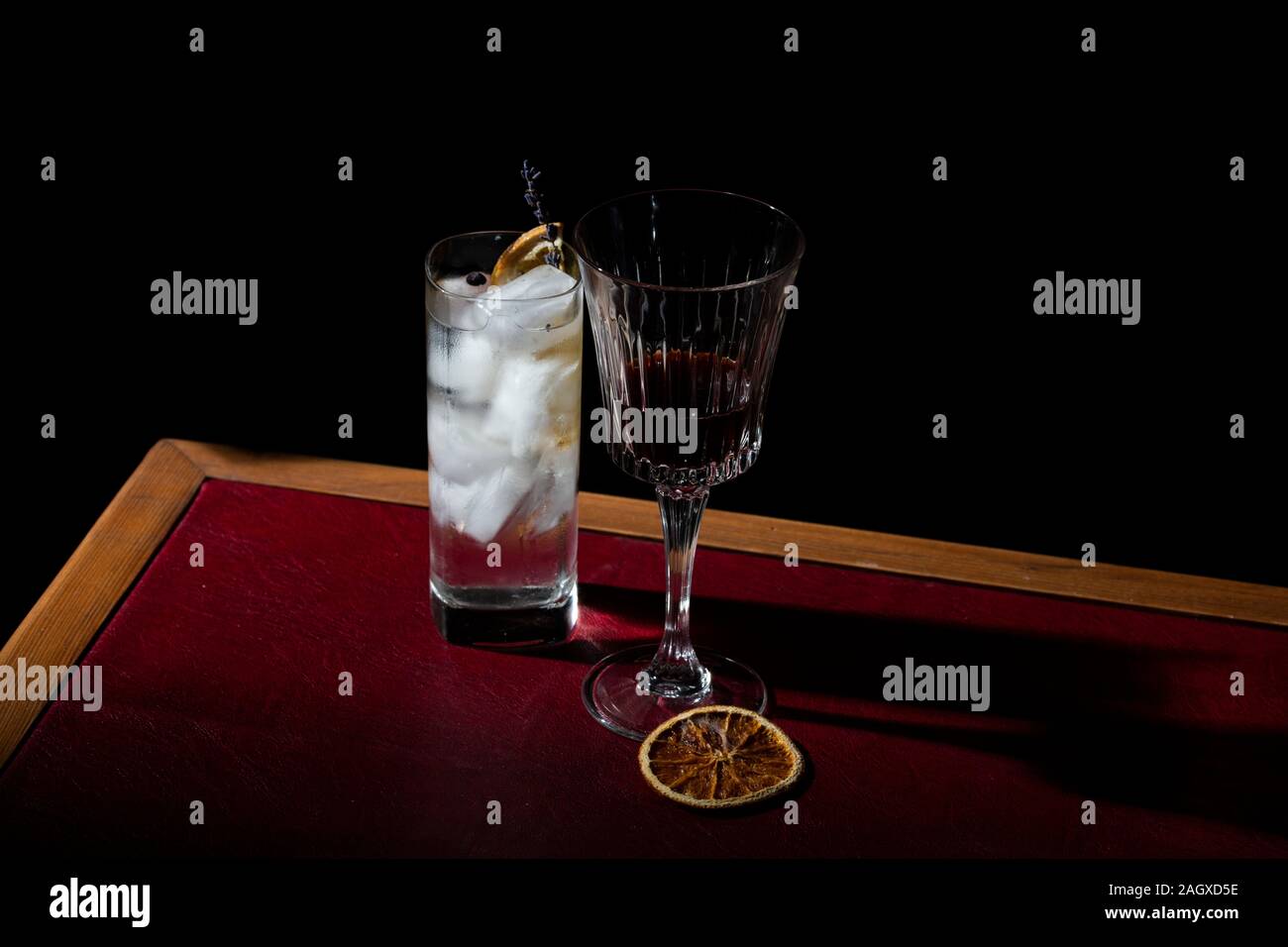 Gin Tonic und roter Wermut garniert mit verkohlter Orange und Lavendel