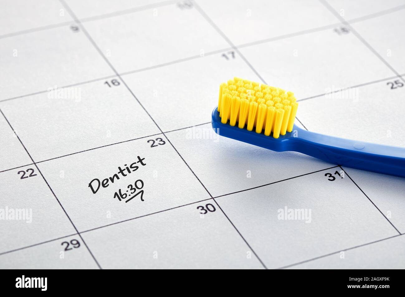 Eine Zahnbürste und ein Hinweis auf Zahnarzt Termin in Kalender. Nähe zu sehen. Stockfoto