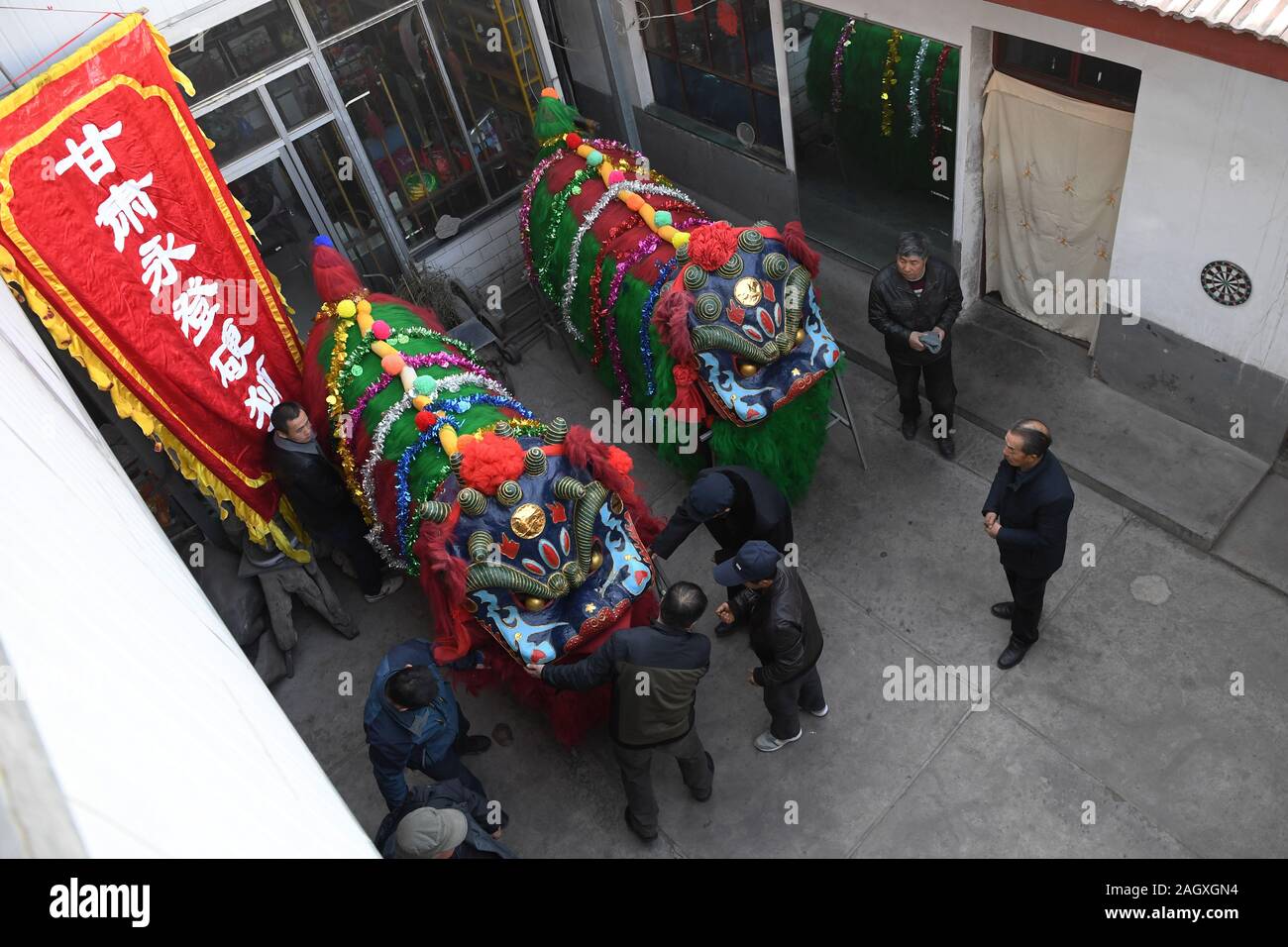 Yongdeng, China. 22 Dez, 2019. Yongdeng (Gansu. 22 Dez, 2019. Folk Künstler machen Sie sich bereit für die Lion Dance Rehearsal in Yongdeng County, Lanzhou, der Hauptstadt der Provinz Gansu im Nordwesten Chinas, Dez. 22, 2019. Lion Dance ist eine traditionelle darstellende Kunst Chinas. Yongdeng Lion Dance, ein lokaler Stil von Lion Dance für seine unverwechselbare und komplizierte Bewegung bekannt, wurde als die immateriellen Kulturerbes der Provinz Gansu im Jahr 2011 aufgeführt. Der Löwe Kostüm, von Holzleisten im Inneren, ist etwa 2,8 Meter lang und 1,8 Meter hoch, so dass der Tanz eine anspruchsvolle Aufgabe für Künstler unterstützt. Credit: Xin Stockfoto