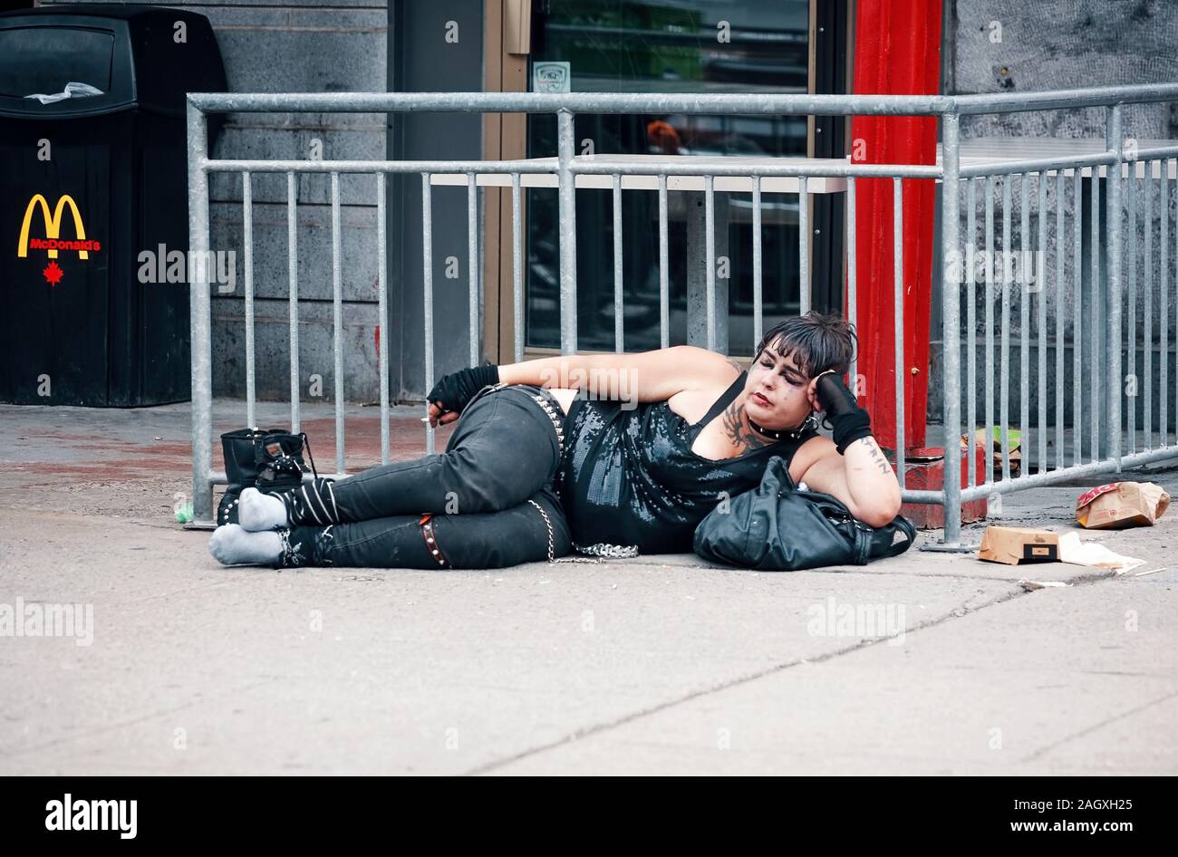 Montreal, Kanada - Juni, 2018: Junge obdachlose Frau schlafen vor einem Burger Restaurant in Montreal, Quebec, Kanada. Stockfoto