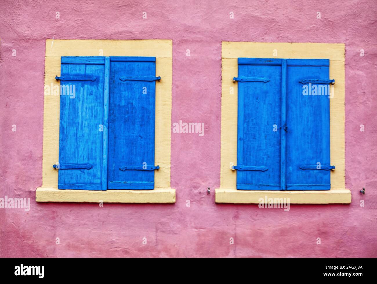 Rosa Wand mit blauen Fenstern Stockfoto