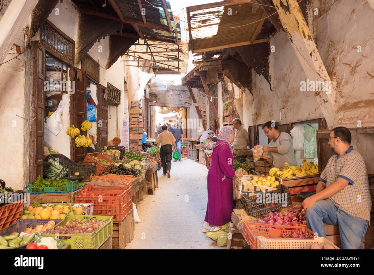 Eine Frau, die in der Medina in Fez, Marokko, Lebensmittel kauft Stockfoto