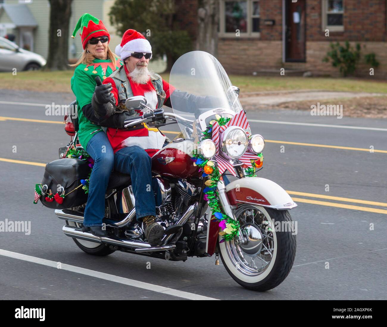 Pennsylvania, USA. 21 Dez, 2019. Debbie Kaelin von Bensalem, reitet auf dem Rücken einer Harley Davidson mit Gary Gifford von Bensalem, verkleidet als Weihnachtsmann, zusammen mit anderen Mitgliedern der Delaware Senke Bügeleisen indischen Riders Association, die ihre jährlichen Fahrt hielt der Weihnachtsmänner und Spielzeug für Kinder am Samstag, 21. Dezember 2019 in der St. Francis-St Vincent Home für Kinder in Bensalem, Pennsylvania. Credit: William Thomas Kain/Alamy leben Nachrichten Stockfoto