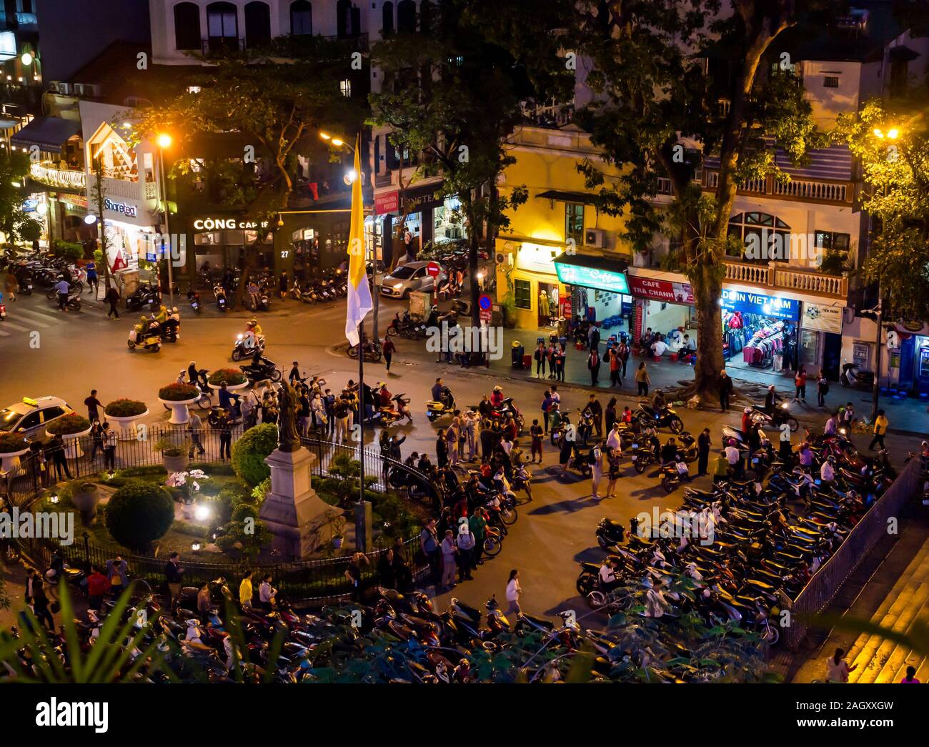 Motorräder und Menschen in überfüllten Square bei Nacht, Hoan Kiem District, Hanoi, Vietnam, Asien Stockfoto