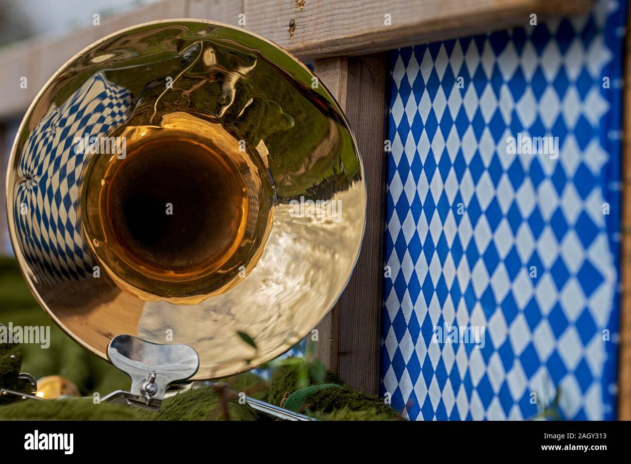 Nahaufnahme einer Posaune tuba mit Reflexion einer Tapete in weißen und blauen Rautenmuster auf einem Wagen an einer bayerischen Festival Stockfoto