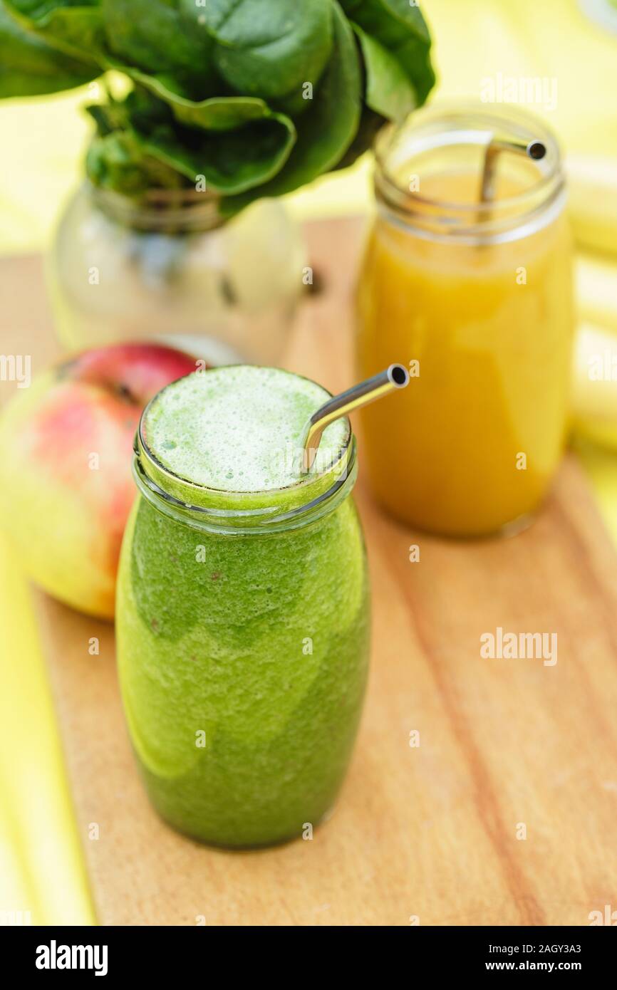 Smoothies in den Gläsern auf Gelb mit grünen verschwommen Garten als Hintergrund. Gesund Sommer trinken Konzept Stockfoto
