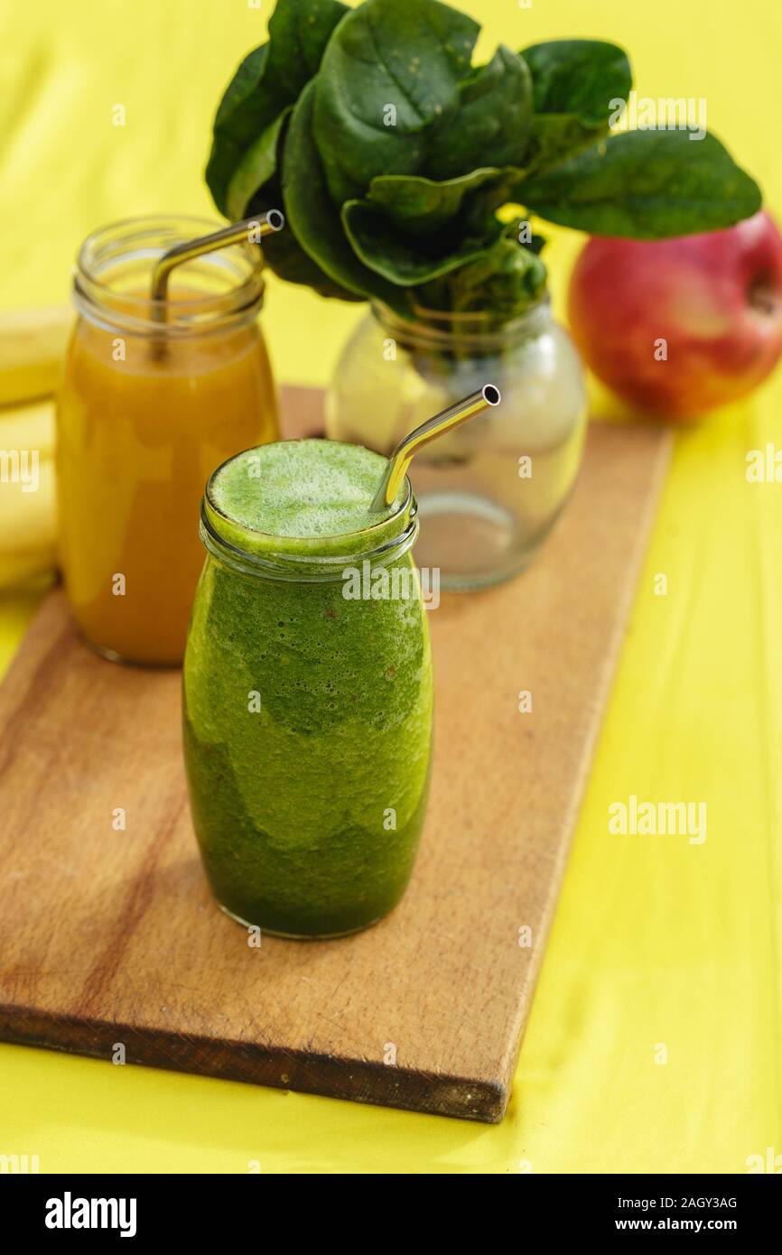Smoothies in den Gläsern auf Gelb mit grünen verschwommen Garten als Hintergrund. Gesund Sommer trinken Konzept Stockfoto