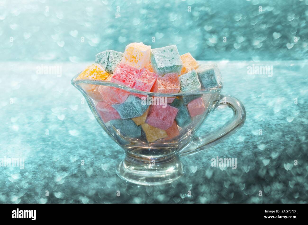 Turkish Delight kleine bunte Eiswürfel in ein Glas Schüssel, auf dem Hintergrund der Bokeh Stockfoto