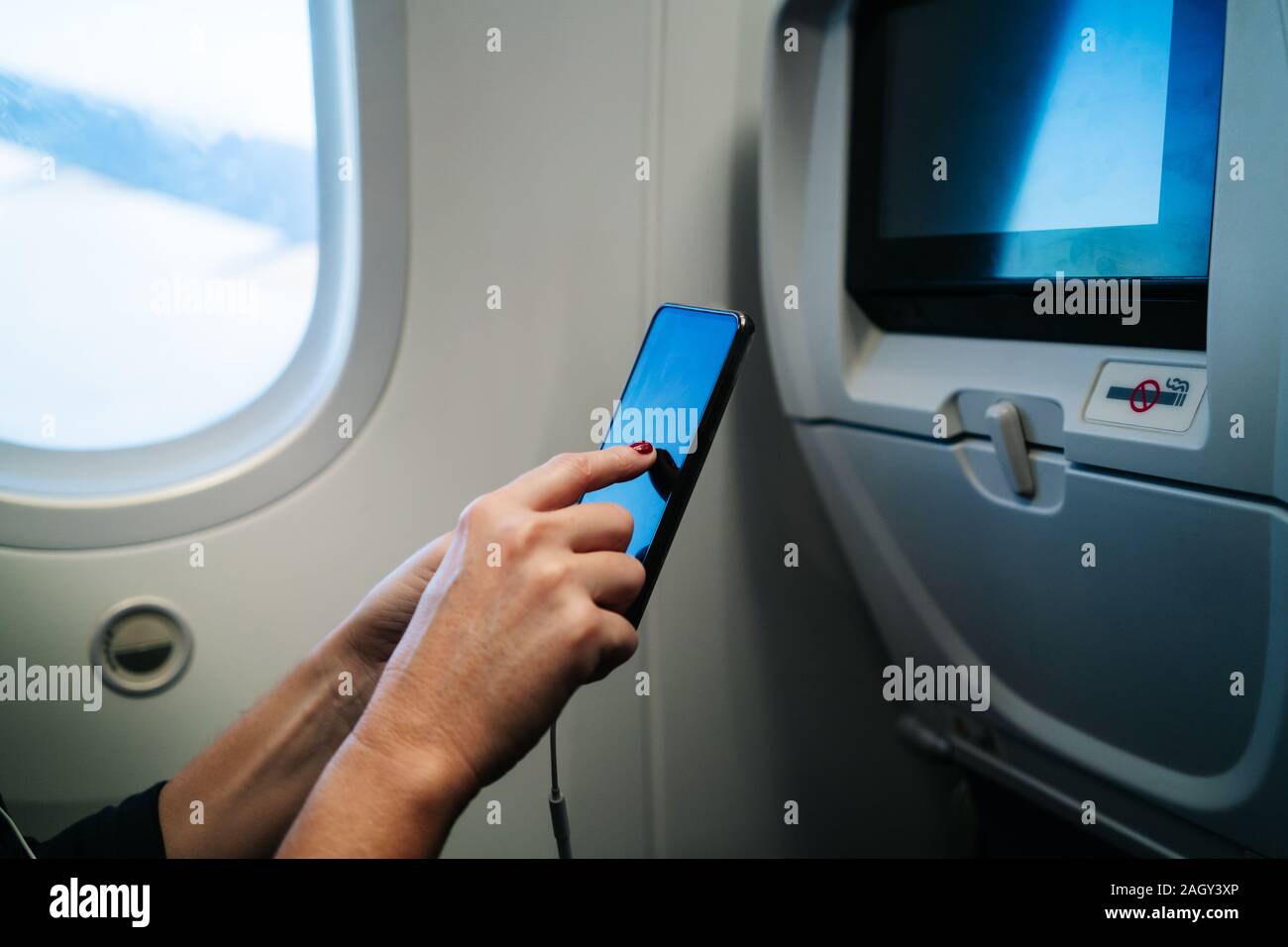 Mit Handy Sitzen im Flugzeug Detail in die Hände einer Frau Stockfoto