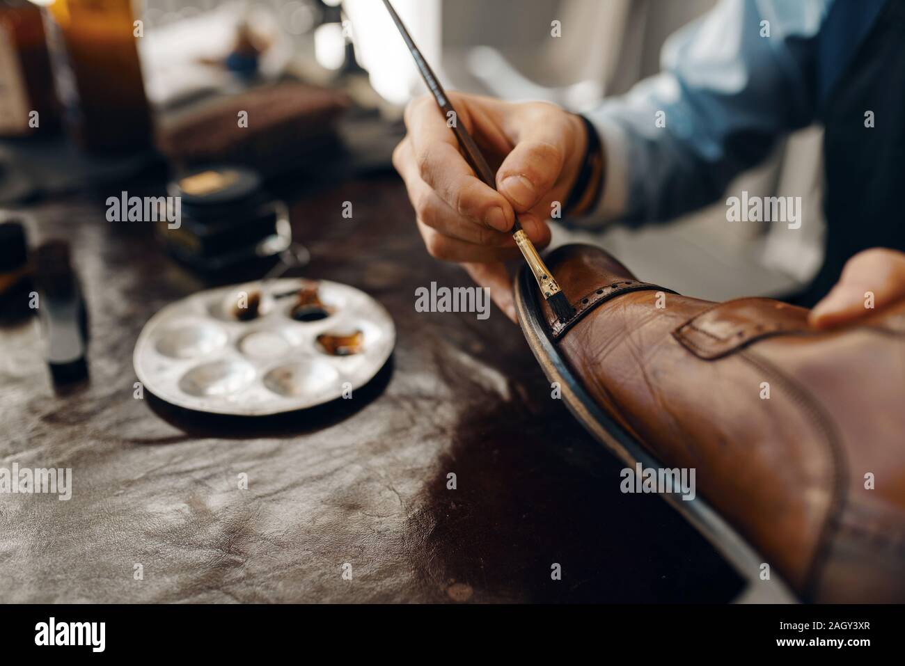 Schuster mit Pinsel Tönungen Schuhe, Schuhe reparieren Stockfoto