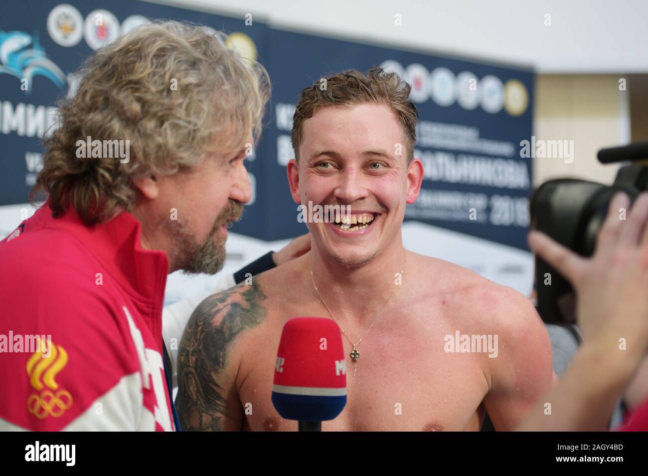 St. Petersburg, Russland - Dezember 20, 2019: Oleg Kostin Gespräche mit Drücken Sie, nachdem Sie den zweiten Platz in 50m Brust schwimmen Wettkämpfe von Salnikov Stockfoto