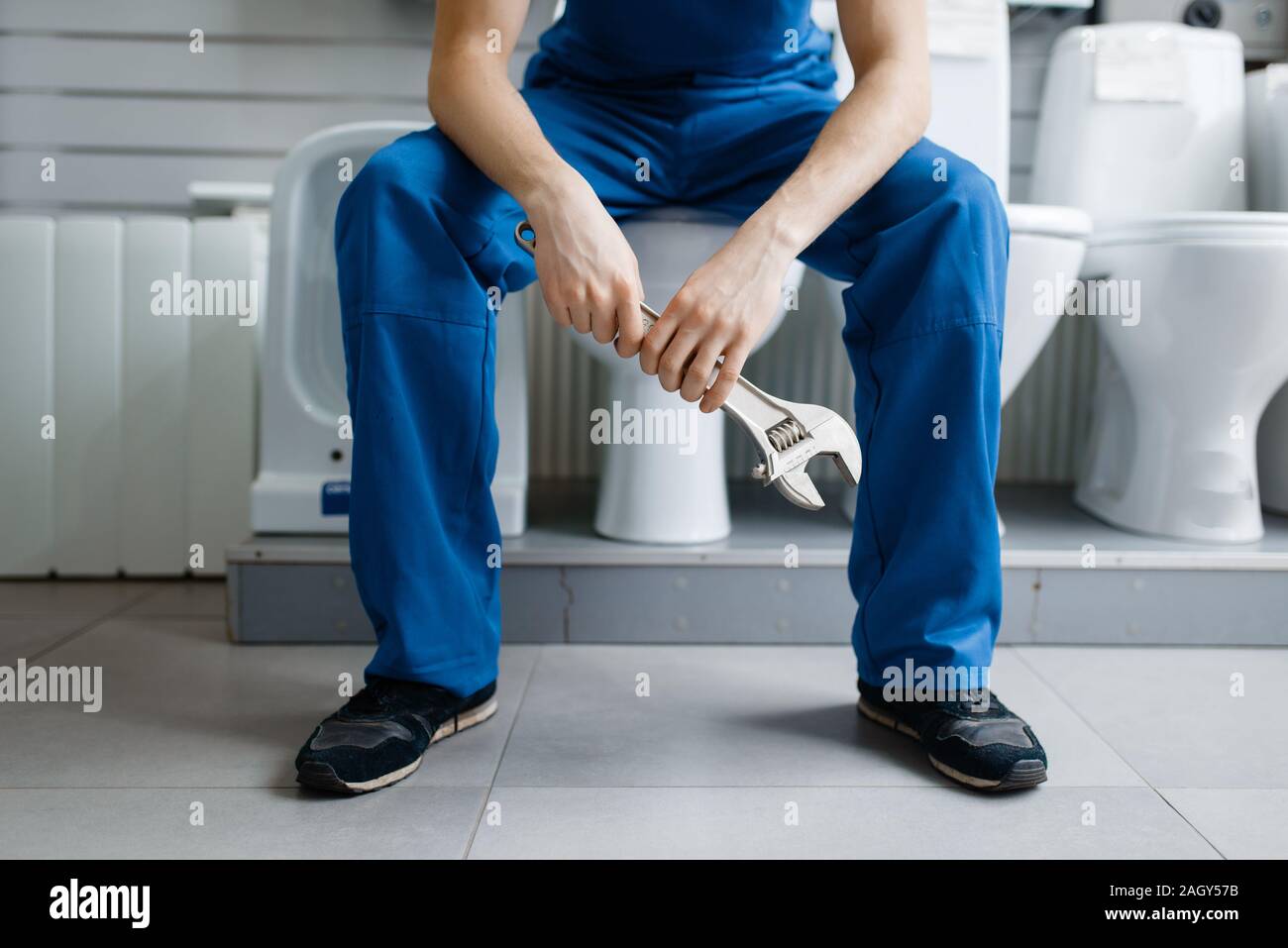Klempner in Uniform sitzen auf Toilette in plumbering Stockfotografie -  Alamy